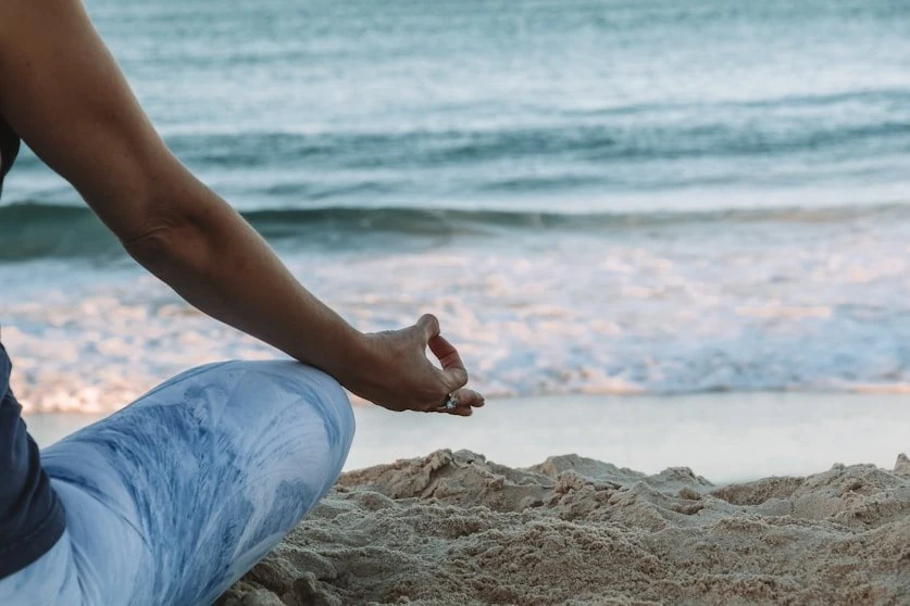 A practitioner meditating at the edge of the shore