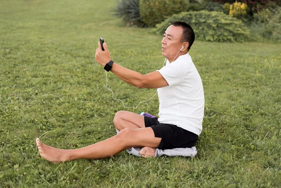 A practitioner sitting on the grass after a morning practice